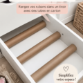 Un atelier créatif bien organisé avec des rubans rangés dans des tubes en carton.