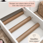 Un atelier créatif bien organisé avec des rubans rangés dans des tubes en carton.