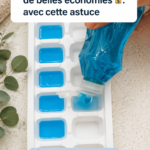 Une femme souriante nettoie sa cuisine avec des produits naturels pour faire des économies.